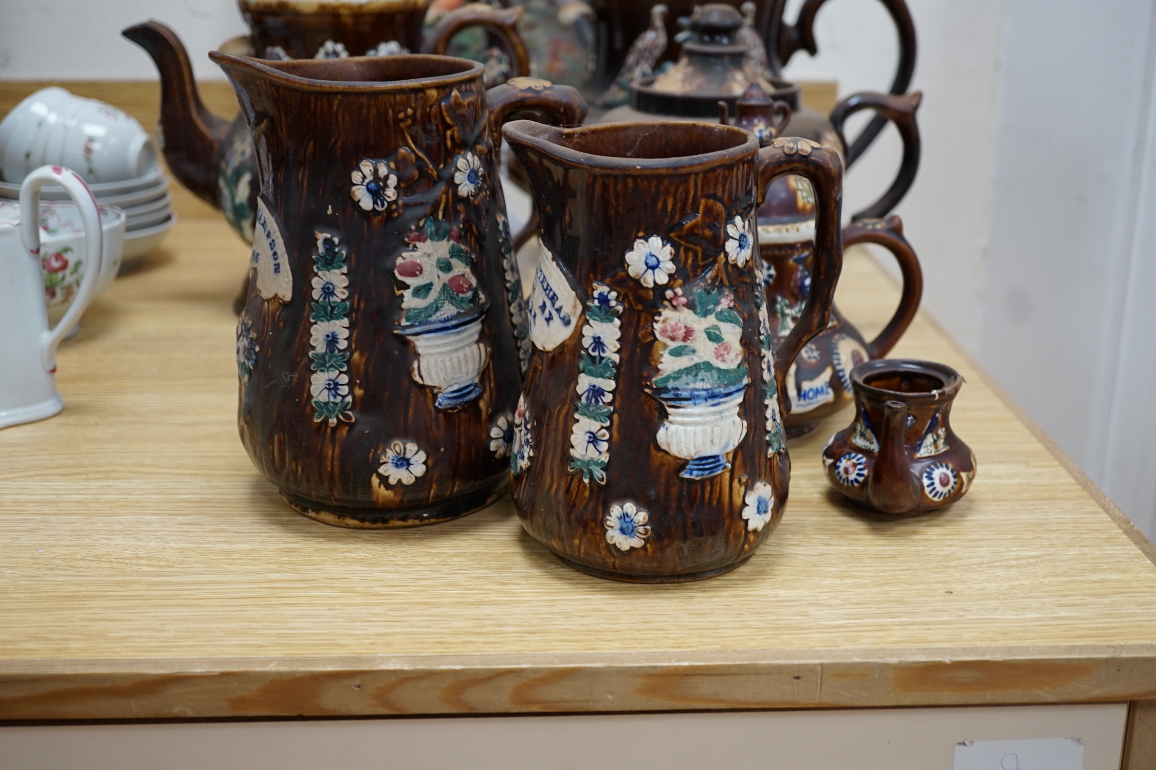 A Measham Barge ware glazed pottery teapot, decorated in relief, 28cm wide